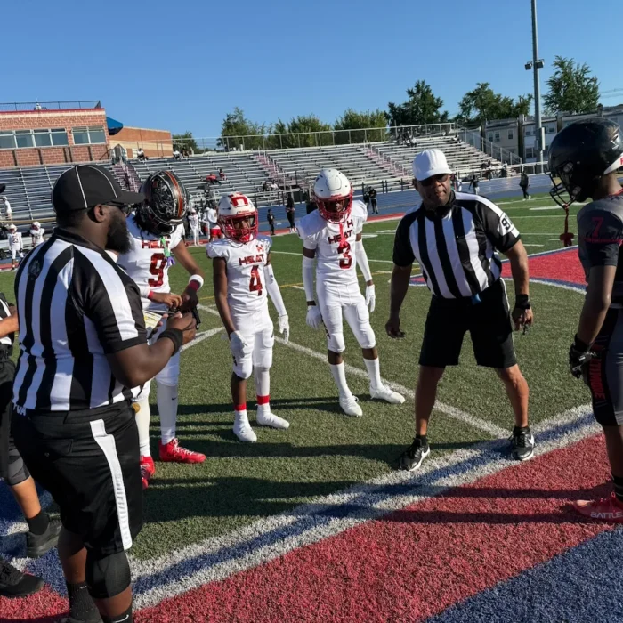 Referees and team captains meeting at midfield for the coin toss