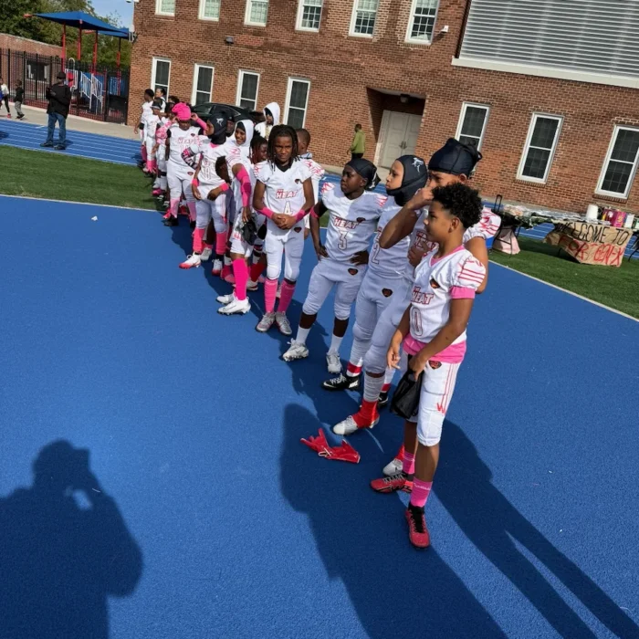 Team lined up in pink Think Pink accessories before a game