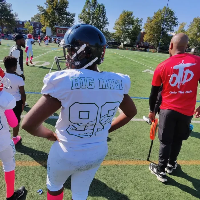 Player number 99 on the sideline wearing pink Think Pink socks